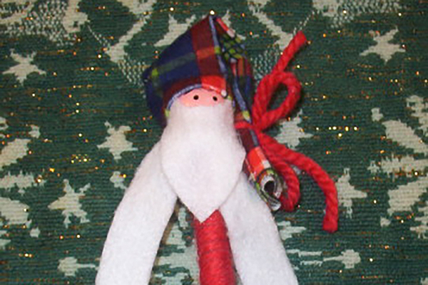 This is a photo of tying the wool on the hat of he Festive Santa Pen Craft project